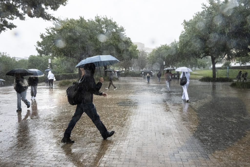 UCI students walk in heavy rain on Ring Road