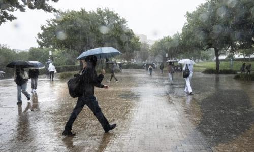 UCI students walk in heavy rain on Ring Road
